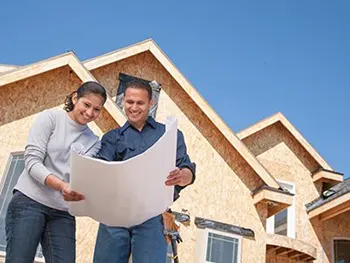 man and woman looking over building plans