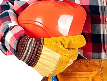 gloved hand holding a hard hat