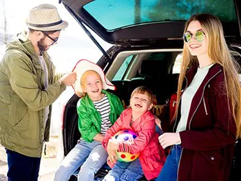 family sitting in tailgate of vehicle